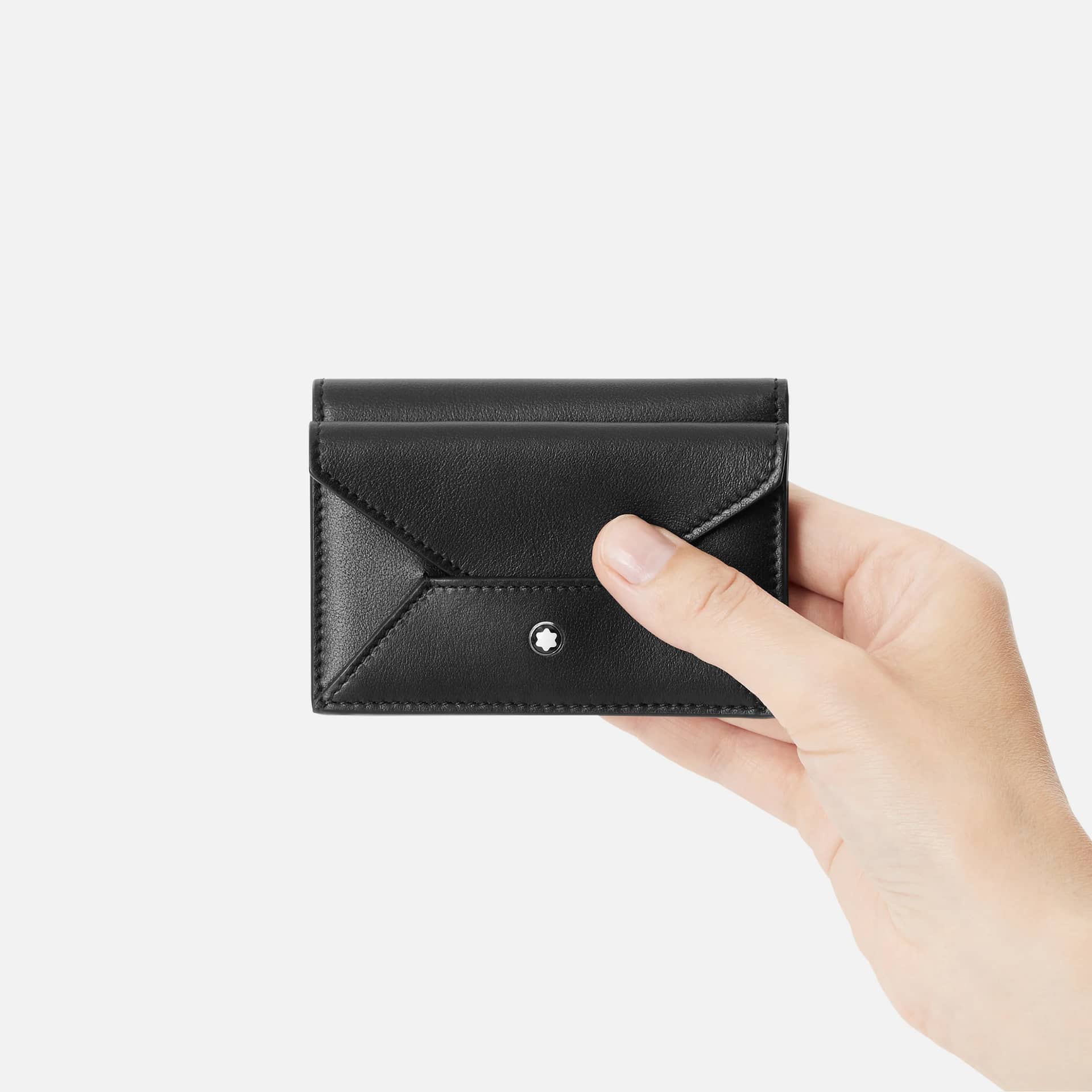 Porta carte Montblanc Soft nero tenuto in mano con chiusura a patta ed emblema