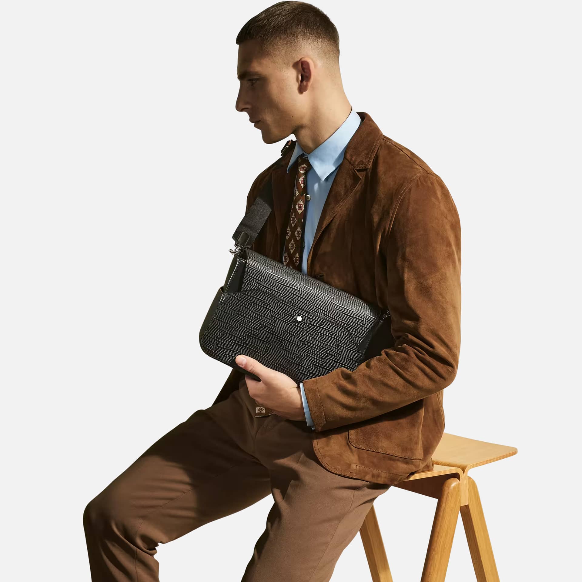 Messenger Bag 4810 Montblanc in pelle nera con motivo corteccia indossata con outfit elegante